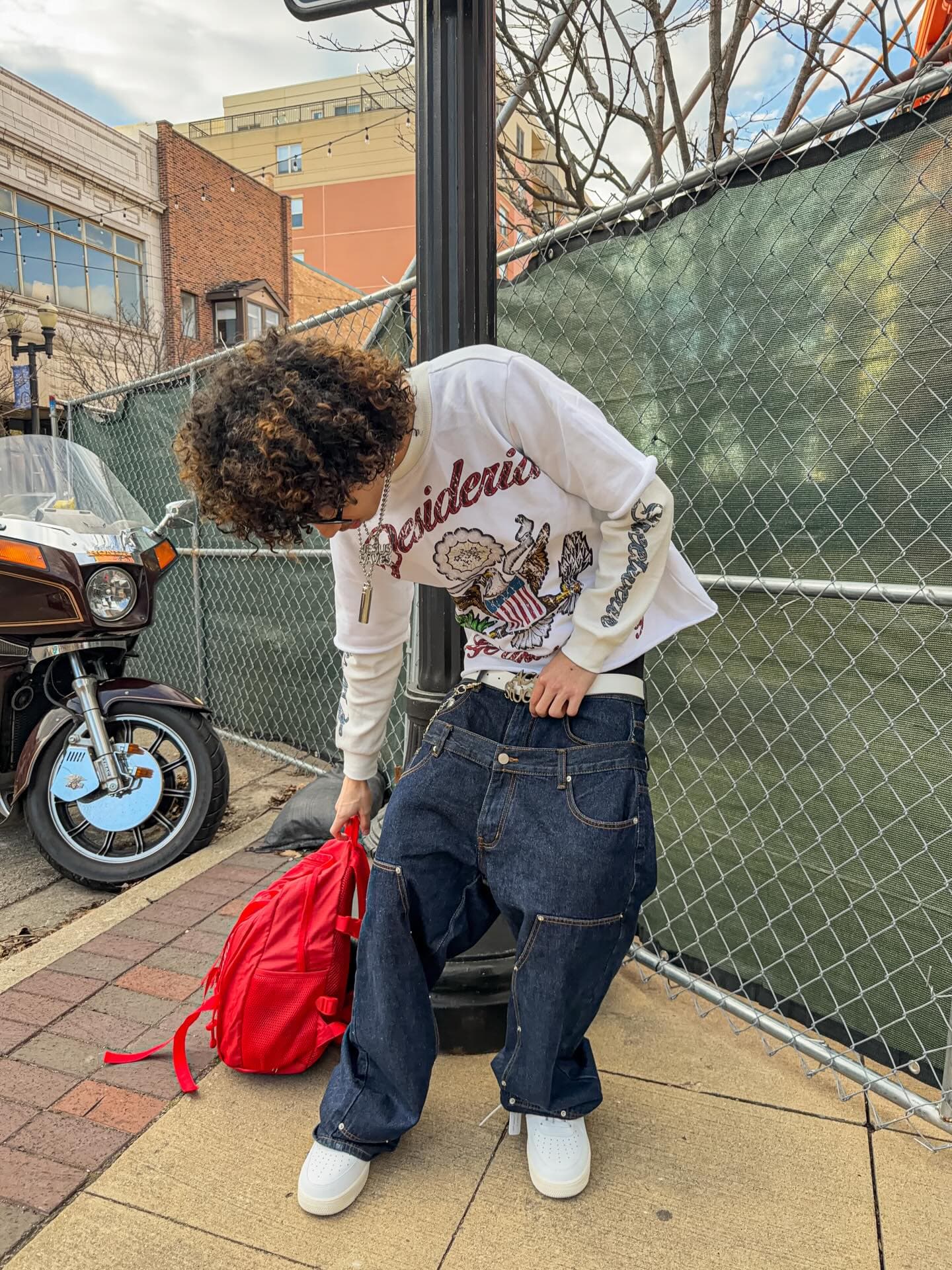 Leaning over in the double sleeve by the fence, red backpack on the ground