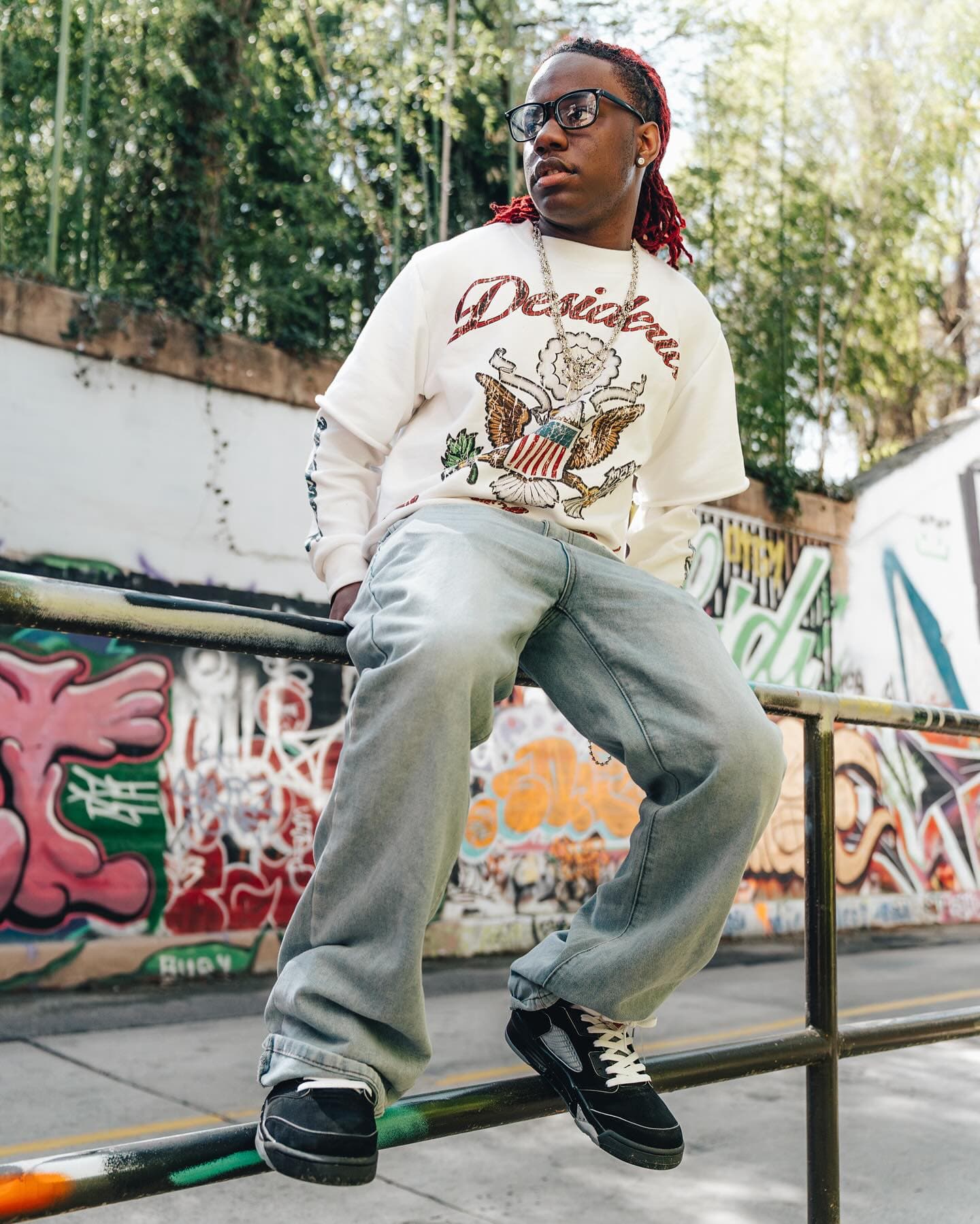 Sitting on a painted rail in the double sleeve and light-wash denim